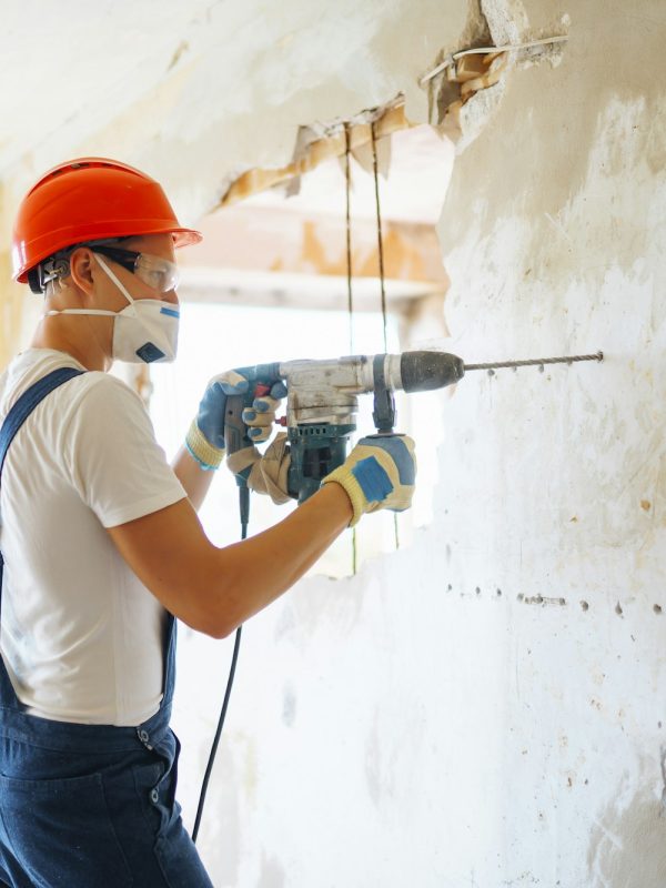 Repairer in boilersuit holding tools. Apartment repair and renovation concept. Building.